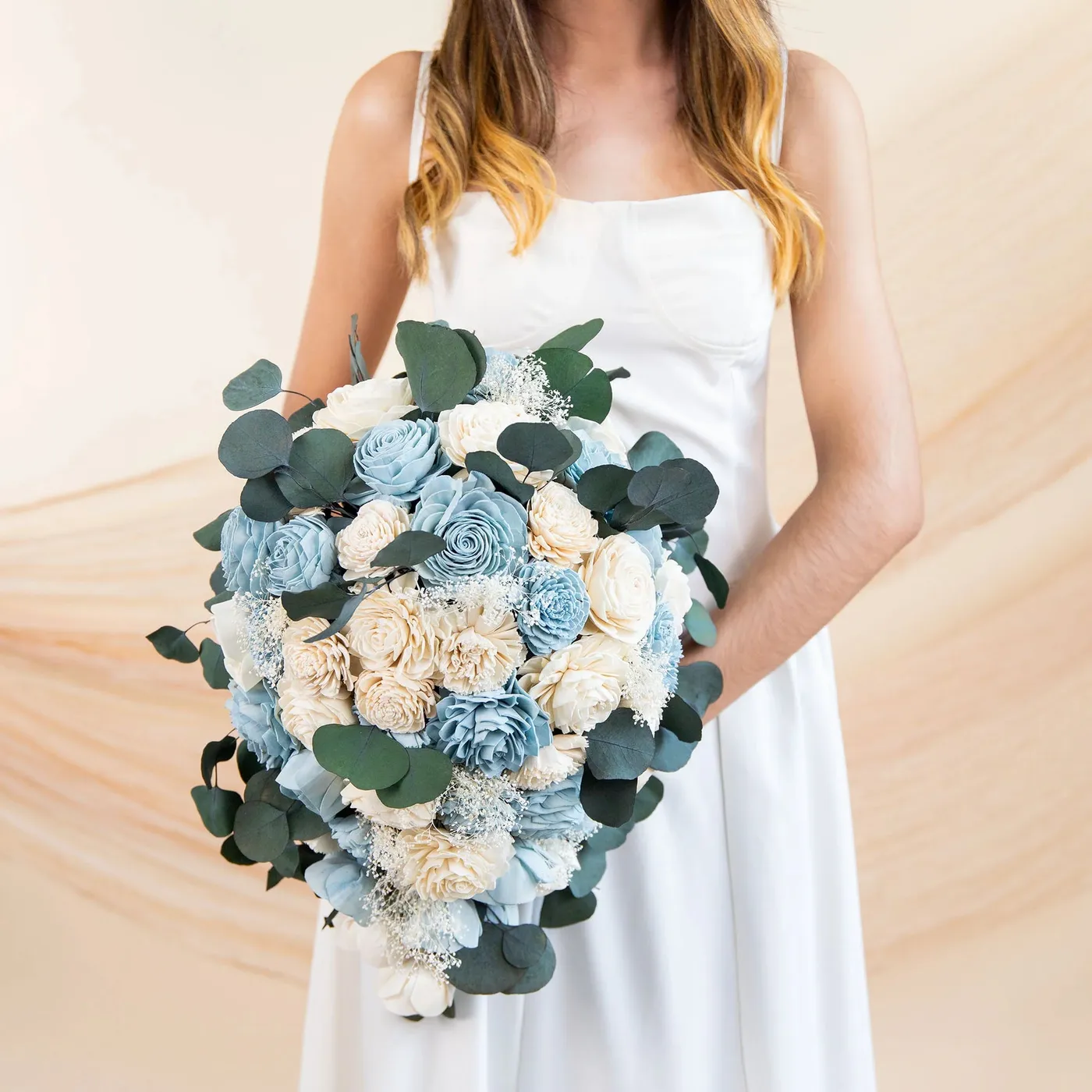 Bride holding the Eloise bouquet in dusty blue and cream with eucalyptus