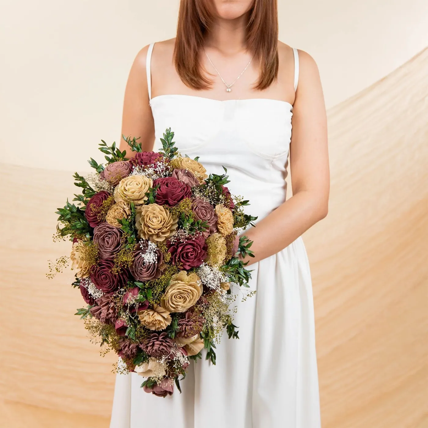 Bride holding the Vintage Vineyard bouquet in wine, tan and green