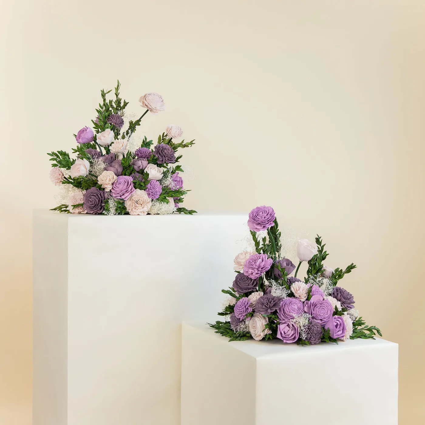 Two free standing floral arrangements in lavender and green on plinths