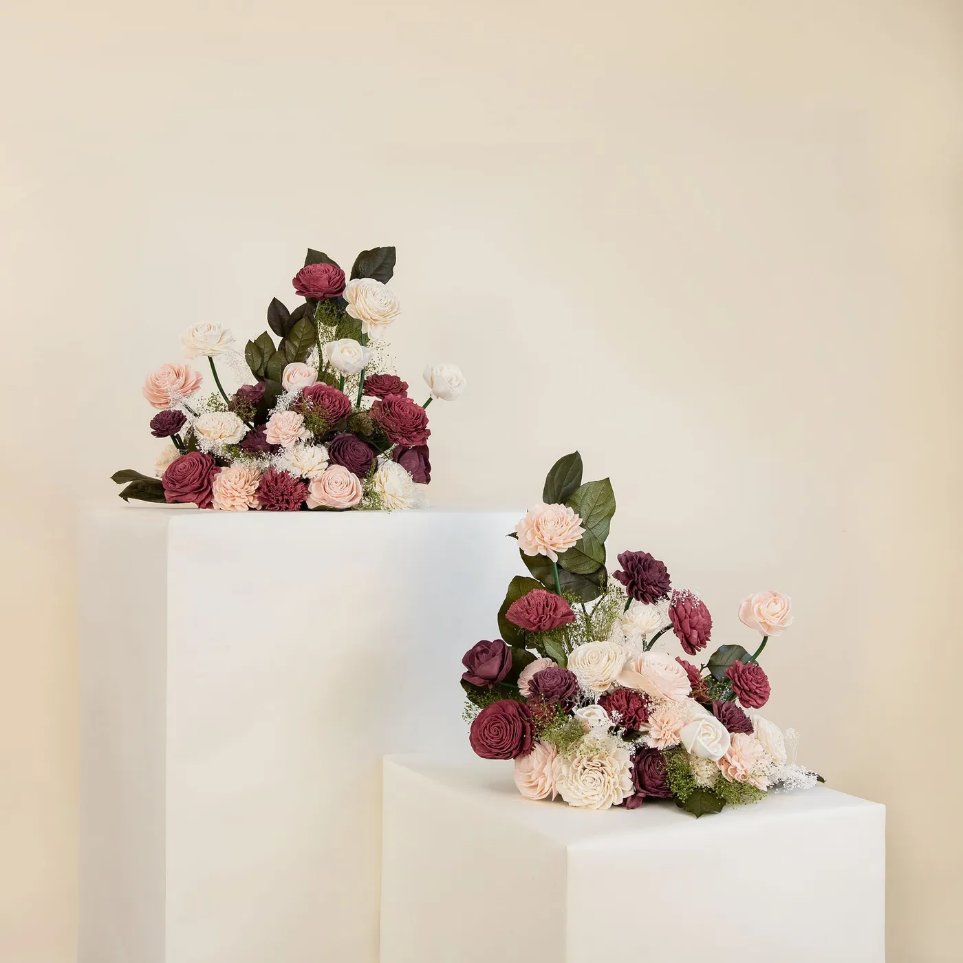Two Love Story free standing floral arrangements on white plinths