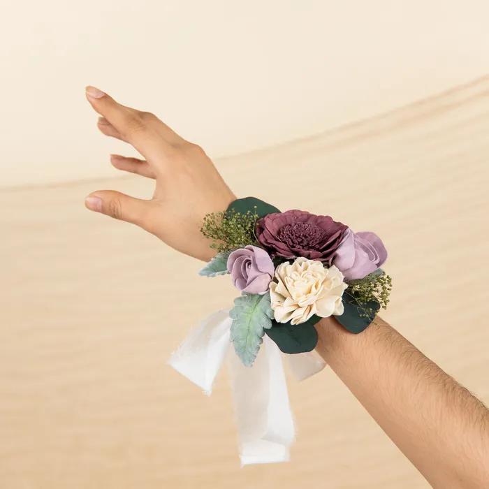 Wrist wearing the Luxe Lavender special corsage with white ribbon